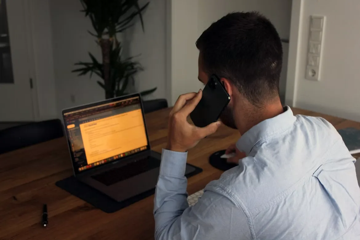 Un hombre hablando por teléfono desde su lugar de trabajo