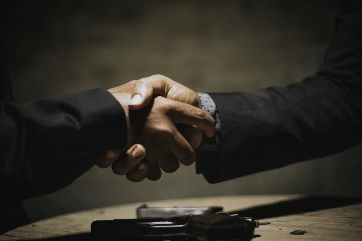 Dos personas cerrando un trato con un apretón de manos
